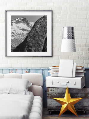 Monochrome alpine landscape with rugged cliffs and lingering snow