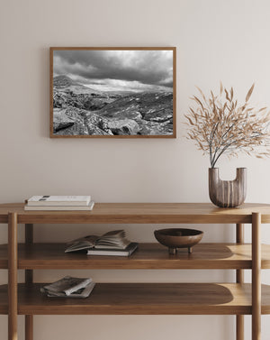 Storm clouds above a rugged hillside and distant Irish mountains