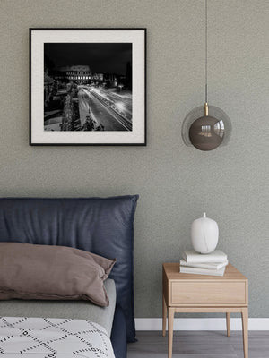 Black and white Rome cityscape with glowing street lamps and ancient stone arches