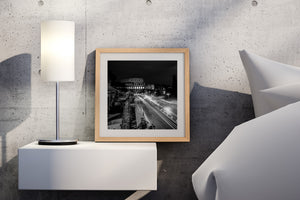 Monochrome photograph of Rome’s amphitheatre and bright moving traffic