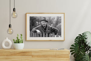 Romanian village farmer standing behind rustic wooden fence monochrome