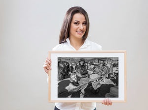 Elderly man resting on produce cart at outdoor market