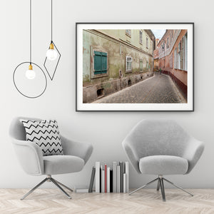 Colour photograph of worn plaster walls along a quiet Romanian lane