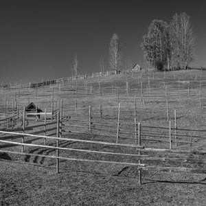 Wooden farm fences crossing agricultural hillside in Romania