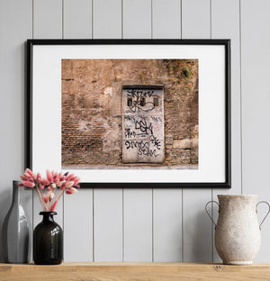 Crumbling plaster and brickwork around a narrow Roman doorway
