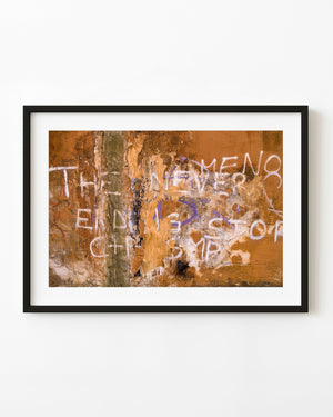 Weathered orange Roman wall with faded white and purple graffiti