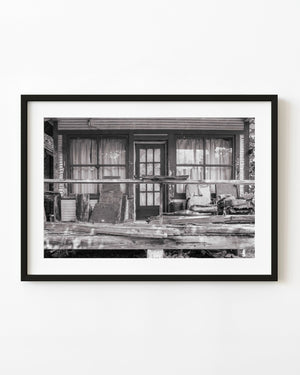 Abandoned Route 66 porch with weathered railings and torn chairs