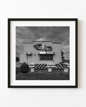 Black and white Route 66 car shop with painted sports car mural