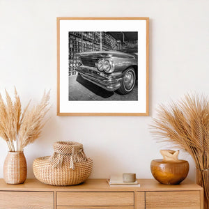 Stacked vintage cans behind classic Pontiac car