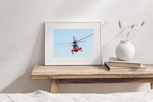 Sea King helicopter approaching with rotor blades spread across the sky