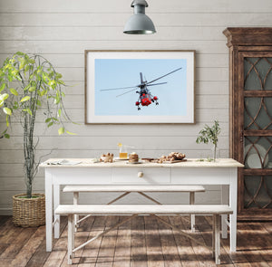 Red rescue helicopter viewed from below with landing gear extended