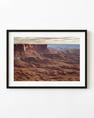 Layered red canyon cliffs beneath a softly clouded Arizona sky