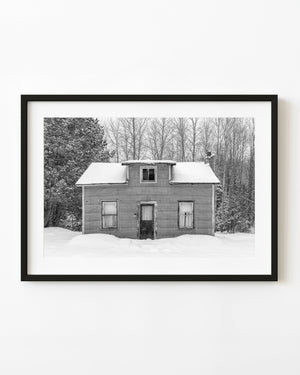 Small weathered Ontario house surrounded by deep snow