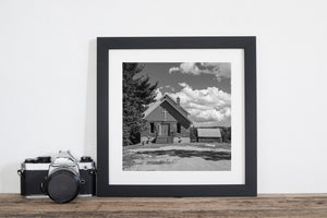 Small United Church framed by trees and an open cloud-filled sky