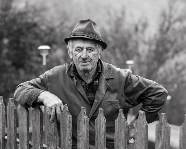 Romanian farmer leaning on fence