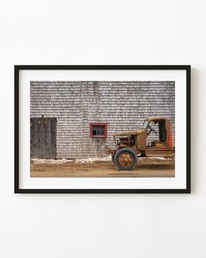 Old rusted truck against wooden barn wall