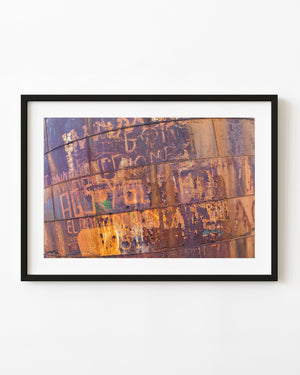 Rusted metal panels covered with faded graffiti and riveted seams