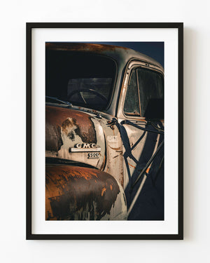 Rusted GMC 9500 truck cab with faded paint and dark windows