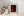 Colour still life of flickering candles behind dark iron bars