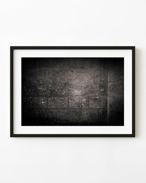 Graffiti-covered stone wall at Sagrada Familia in black and white
