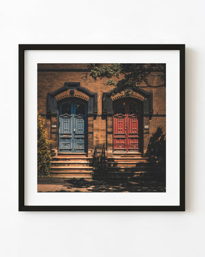 Blue and red doors beneath tree shadows in Saint John