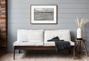 Natural curves and streaks in beach sand beside cold coastal water