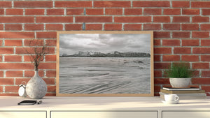 Muted coastal landscape with flowing sand textures and distant mountains