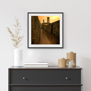 Warm-toned San Gimignano architecture along a deserted paved street