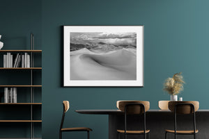 Sweeping sand formations in front of rugged desert peaks