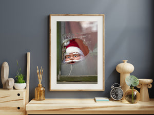 Santa face with spectacles peering through a damaged frosted window