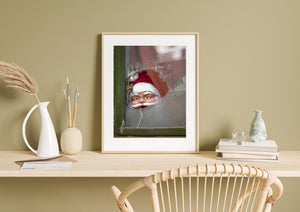 Weathered window frame and shattered pane surrounding a Santa decoration