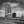 Old wooden grain elevator beside railway tracks beneath prairie clouds