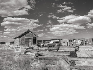 Old West prairie schoolhouse with vintage trucks and trailer