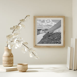 Black and white alpine scene with a sculpted snow edge and distant peaks