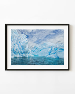 Blue and white sculptural Antarctic icebergs above dark rippled water
