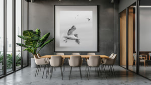 Flying seabird with other birds softly blurred in the distance
