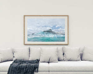 Turquoise seawater beside a sediment-streaked iceberg
