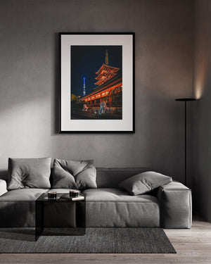 Framed photograph of a traditional Japanese temple on a wall above a gray sofa.