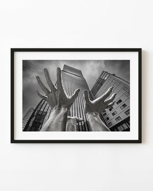 Giant hand sculpture beneath Seoul skyscrapers in black and white