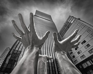 Upward view of metallic hands reaching toward modern Seoul towers