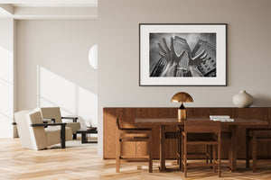 Sculpted open hands framed by glass buildings and cloudy sky