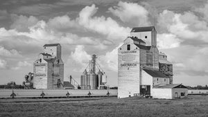 Schwarz-Weiß-Foto von Prärie-Getreidesilos mit Triebwagen und Wolken