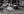 Motion-blurred pedestrians crossing striped wet pavement in Tokyo