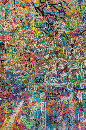 White handwritten marks over turquoise pink and yellow paint
