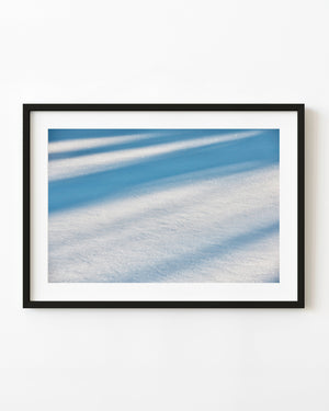 Shimmering snow and blue shadows across a frozen lake