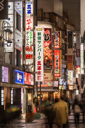 Glowing Japanese restaurant signs above blurred pedestrians in Tokyo