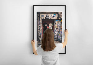 Weathered street-art entrance with cartoon characters and layered posters