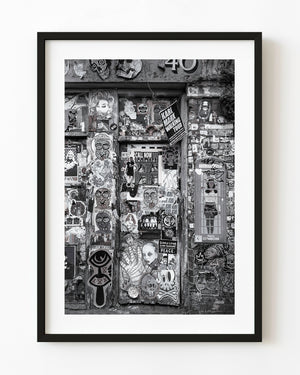 Sticker-covered Shoreditch doorway in monochrome
