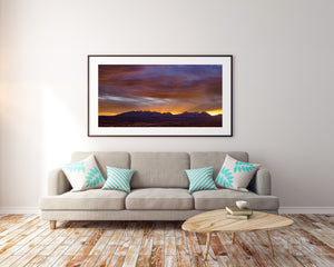 Layered purple and grey clouds above the Sierra Mountains at sunset.