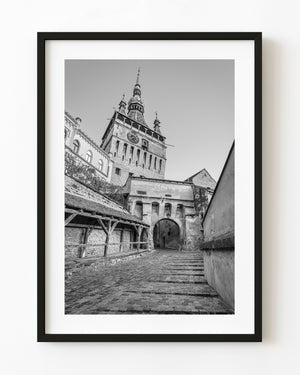 Sighisoara clock tower above a cobbled passage in black and white